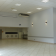 Salle vide avec éclairage, climatisation, porte, extincteur et mur décoré.