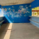 Abri avec bancs, murs bleus et peinture murale.