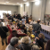 Salle d'exposition avec tables, stands, produits en vente et personnes.