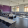Salle de classe avec tables, chaises, télévision et fenêtres.
