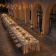 Salle à manger extérieure avec tables, chaises, nappes, guirlandes lumineuses et lanternes.