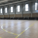 Gymnase avec gradins, parquet et lignes de terrain.
