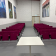Salle de classe avec chaises, table et tableaux aux murs.