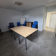 Salle avec table, chaises, tableau blanc et porte.