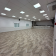 Salle vide avec moquette, lumières, fenêtres et climatiseur.
