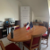 Pièce avec table, chaises, ordinateur, imprimante, et deux drapeaux.