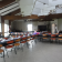 Salle avec tables, chaises, vaisselle, ballons, matériel de projection et équipement audio.