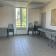Salle avec tables, chaises, tableau et fenêtre.