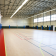 Salle de sport avec paniers de basket, sol, murs et filets.
