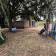 Jardin avec bancs, chaises, table et cabane.