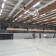 Salle de sport avec panier de basket, gradins et éclairage.