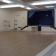 Salle vide avec parquet, estrade, écran, tabouret, portes et climatiseurs.