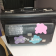Valise noire avec autocollants et inscriptions, posée sur une table.