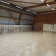 Salle de danse avec parquet, barre, miroir, rideau et matelas rouge.