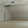 Salle vide avec éclairage, climatisation, porte et sortie de secours.