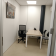 Petite salle de réunion avec table, chaises, téléphone et tableau.