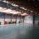 Salle de sport avec paniers de basket, gradins, et sol vert.