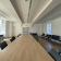 Salle de réunion avec table, chaises, et lumières.