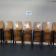 Dix piles de chaises empilées, mur blanc avec signalisation "CHAISES PAR 10".