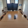 Salle de réunion avec table, chaises et écran.