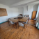 Salle avec table, chaises, tableau blanc, étagères et armoire.