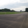 Terrain de sport avec piste d'athlétisme, pelouse et but de football.