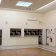 Salle vide avec portes, climatiseur, extincteur et sorties de secours.