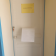 Porte blanche avec cadre bleu, poignée, serrure, affiche jaune et papier accroché.