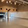 Salle vide avec éclairage, haut-parleurs, et porte vitrée.