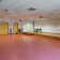 Salle avec tables, chaises, tableau, placard, portes et extincteur.