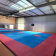 Salle de sport avec sol en parquet et tatamis.