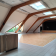 Salle avec plancher en bois, murs en brique, fenêtres, comptoir et porte.