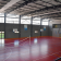 Salle de sport avec paniers de basket, filets de volley-ball et lignes de terrain.
