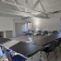 Salle avec tables, chaises, tableau blanc et porte.