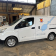 Utilitaire Nissan blanc dans un garage avec outils et étagères.