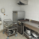 Cuisine avec chariot, plaques de cuisson, hotte, évier, et étagères.