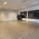 Salle vide avec chaises, portes, fenêtres et radiateurs.