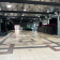 Salle spacieuse avec sol carrelé, éclairage suspendu, rideaux noirs et affiches murales.