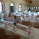 Salle avec tables, chaises, vaisselle, verres, serviettes, fleurs, ballons, fenêtres.