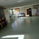 Salle avec tables, chaises, porte, fenêtre, et décorations murales.