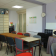 Salle avec tables, chaises, armoires, micro-ondes, calendrier, horloge et plaque murale.