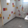 Toilettes avec urinoirs, lavabo, porte et carrelage mural coloré.