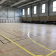 Gymnase avec parquet, lignes de terrain et gradins.