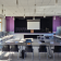 Salle de classe avec tables, chaises, tableau blanc, ordinateur portable, projecteur et écran.