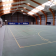 Terrain de sport intérieur avec lignes de tennis et de basket.