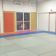 Salle avec tapis, fenêtres grillagées, porte, rideaux et horloge.