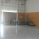 Salle avec rideaux, table, chaises, escaliers et projecteur.