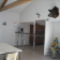 Pièce avec table, chaises, sapin de Noël, étagères, trophées et photos murales.