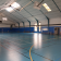 Salle de sport avec paniers de basket, panneaux de handball, échafaudages et portes de sortie.