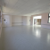 Salle vide avec portes, fenêtres, et extincteur.